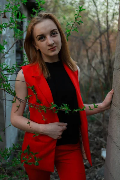 Молода Дівчина Яскраво Червоному Костюмі Стоїть Біля Дерева Стіни Будинку — стокове фото