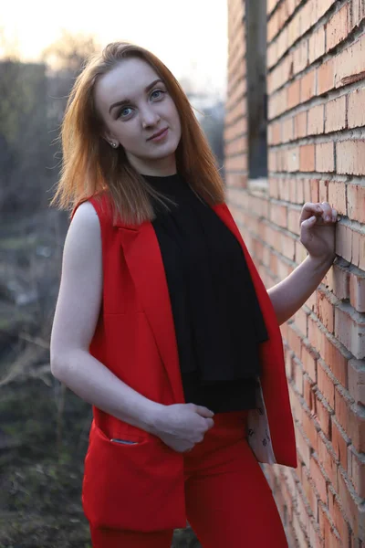 Ein Mädchen Roten Anzug Mit Einem Handy Der Tasche Lehnt — Stockfoto