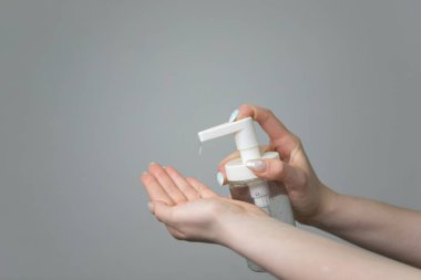 Mikropların, bakterilerin ve virüslerin yayılmasını önlemek için alkol spreyi ya da antibakteriyel jel kullanan bir kızın elleri. Kişisel hijyen kavramı. Evde ya da işte sağlık önleme