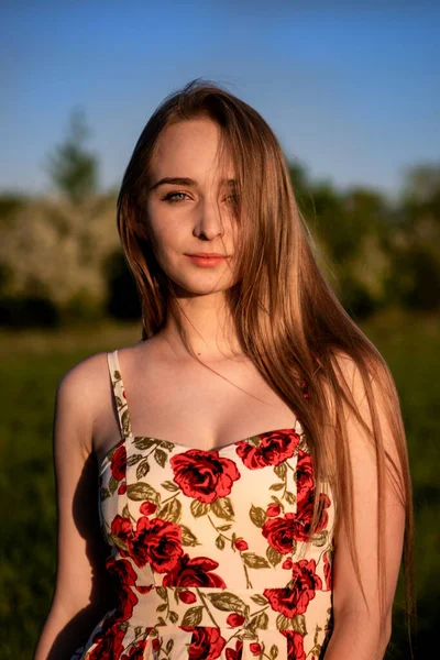 OMSK, RUSSIA, MAY 09, 2020:  Girl in a dress in the evening in the forest. A charming lady enjoys nature during the sunset.