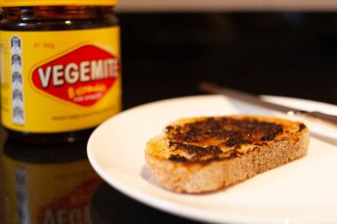 Sydney, Avustralya - 2 Kasım 2019 - Vegemite ve tereyağı kızartılmış ekmek, bıçak ve Vegemite kavanozu. Klasik bir Avustralya ikonu.. 