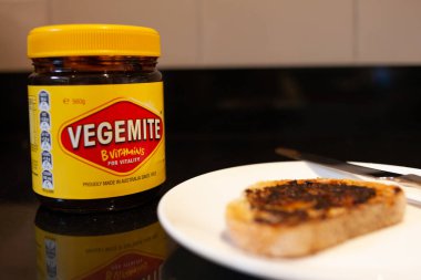 Sydney, Avustralya - 2 Kasım 2019 - Vegemite ve tereyağı kızartılmış ekmek, bıçak ve Vegemite kavanozu. Klasik bir Avustralya ikonu.. 
