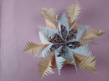 Kağıttan yapılmış Noel kar tanesi masanın üstünde yatıyor.