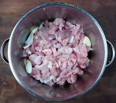 Taze kesilmiş etli bir tava masanın üstünde.