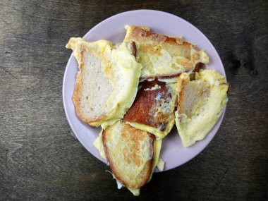 Lezzetli kızarmış yumurta dolu ekmek tabakta yatıyor.