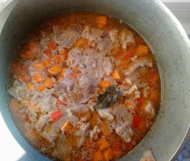 Et, havuç ve kırmızı biberli lezzetli çorba bir tavada pişirilir.