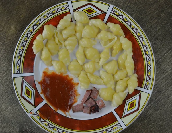 pasta pieces of meat and ketchup are on a plate