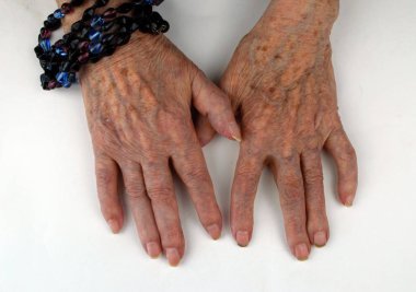 Eski insan elleri beyaz arka planda yatar.