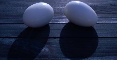 Tahta bir masada iki yumurta yatıyor.