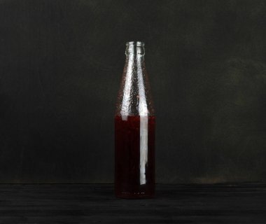 Reçelli şişe siyah arka planda duruyor.