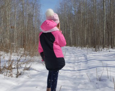 Ormanın ortasında dikilirken telefonda konuşan bir kız.