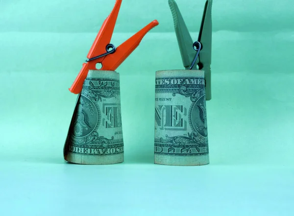 两个用衣针夹住的折叠钞票站在桌子上 — 图库照片