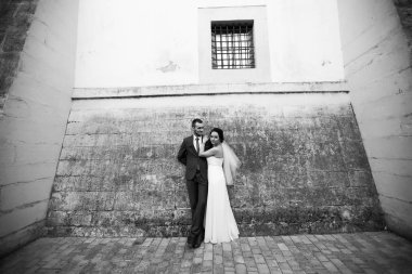 Gelin sevgilisi arka plan gri duvar üzerinde kucaklayan