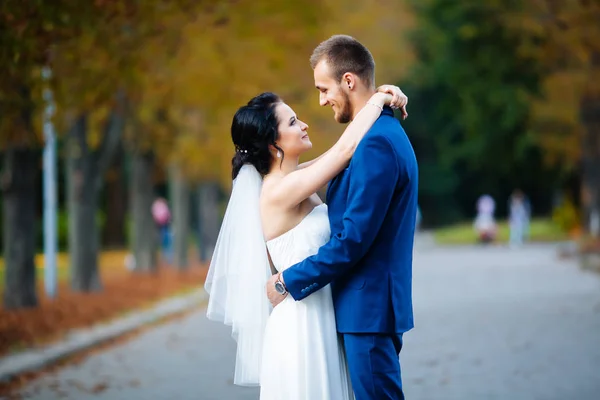 The couple gently hugging in the autumn park — Stock Photo, Image