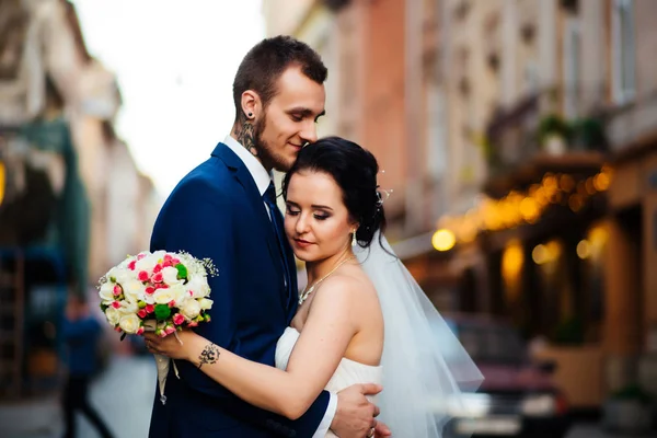 Feliz recém-casados beijando nas ruas da cidade — Fotografia de Stock