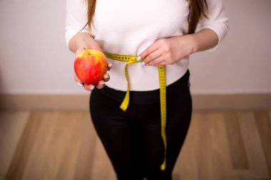 Ölçme bant ve elma ile kadın karin.