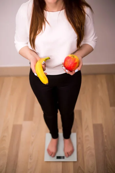 Donna in forma sorridente con scala e mela — Foto Stock