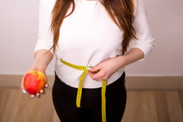Krásná sportovní žena se zelenými jablky a měřicí páska — Stock fotografie
