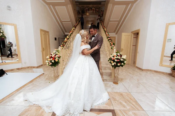 Ein glückliches junges Paar umarmt auf dem Hintergrund eines geschmückten Bogens. Rustikale Hochzeit — Stockfoto