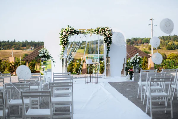 Arc de mariage avec des fleurs blanches à l'arrière-plan des arbres — Photo