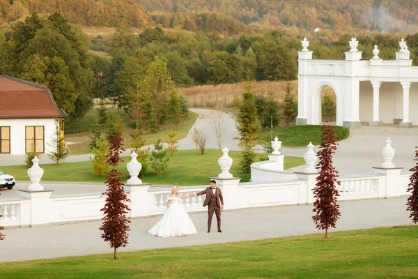 Celovečerní portrét mladé nevěsty a ženicha běžící na zelené trávě golfového hřiště, pohled zezadu. Šťastný svatební pár procházky golfovým hřištěm, kopírovat prostor — Stock fotografie