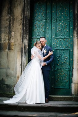 Birbirine aşık çiftler. Düğün günü, kilisenin arka planında.