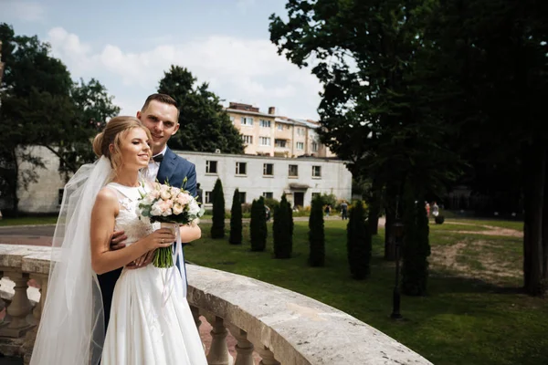 Bruid en bruidegom poseren in de straten van de oude stad, dicht bij de hoek — Stockfoto