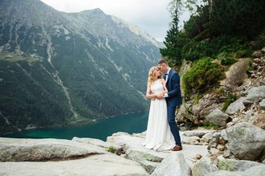 Düğünlerinde mutlu gelin ve damat. Damat gelinin alnından öper. Gelinin portresi. Parkta yeni evliler. Mutlu bir çift. Düğün fotoğrafı. Birbirine aşık çift.