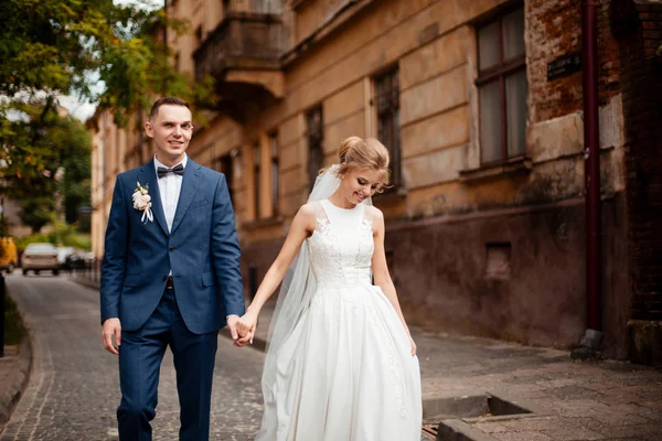 Gorgeous wedding couple walking in the old city — Stock Photo, Image