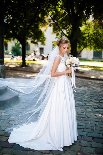 Невеста по всей длине, держа букет цветов — стоковое фото