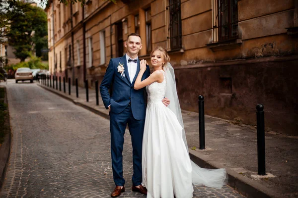 Braut und Bräutigam posieren auf den Straßen der Altstadt, nah am Winkel — Stockfoto