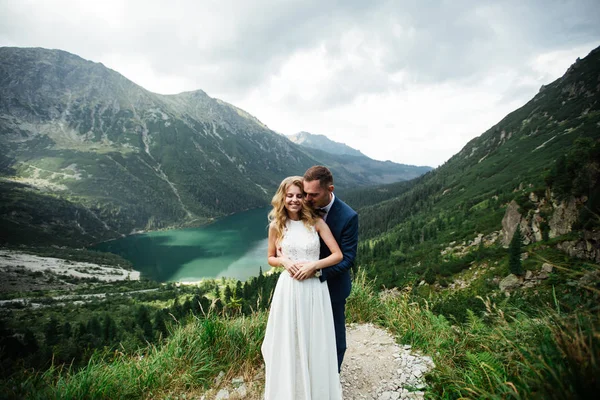 Brud och brudgum på bröllopsdagen promenader utomhus på våren natur. Bröllopspar, glad nygift kvinna och man omfamnar i Green Park. Älskade bröllopspar utomhus. Brud och brudgum — Stockfoto