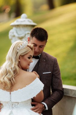 Gelin ve damat, düğün günü açık havada yürüyüş Doğa bahar. mutlu yeni evli kadın ve erkek yeşil park kucaklayan gelin çift. sevgi dolu evlilik çift açık.