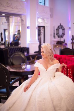 Kanepede çiçekli ve orkideli bir korseyle muhteşem beyaz bir gelinlik içinde güzel bir gelin.