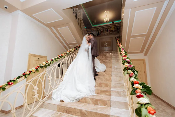 Recién casados en los escalones de flores bellamente decoradas — Foto de Stock