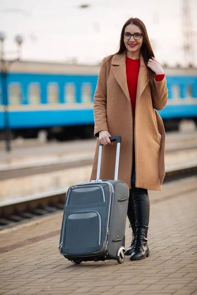 girl in a coat with a suitcase going to the landing zone.