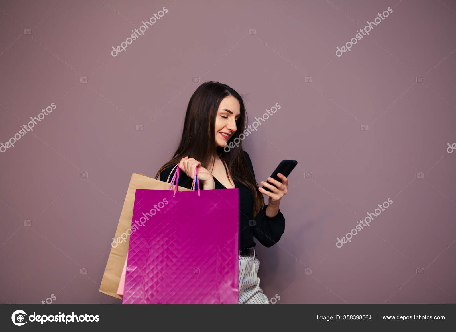 可愛い女の子はスマホを使った買い物袋や笑顔で買い物をしながら ストック写真 C Ostap Davydiak