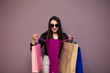 Güzel, sevimli, sevimli, sevimli, sürpriz sarışın kızın portresi. Elinde koca bir çanta tutuyor..