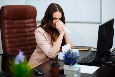 Hızlı yürüyen, yorgun bir iş kadını elinde buruşuk kağıtlarla bir ofis masasında oturmaktan yorgun düşüyor..