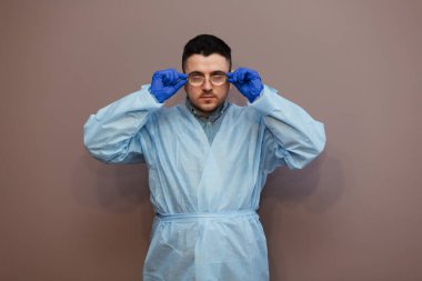 Stüdyo portresi. Yüzü maskeli bir genç. Kameraya bakıyor..