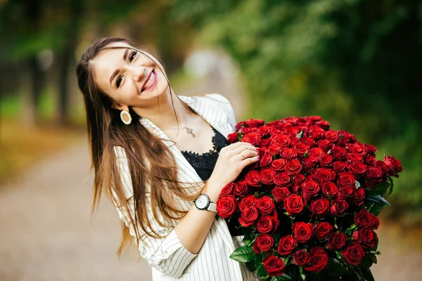 笑顔女の子とともに花束の赤いバラ — ストック写真