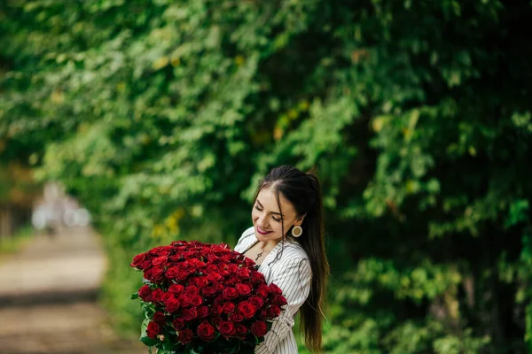 春の花の花束を持つ女性 幸せな驚きのモデルの女性の花の香り 母の日 — ストック写真