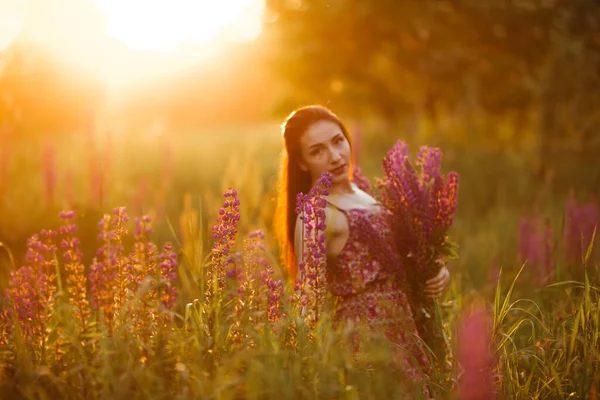 Piękna Młoda Kobieta Polu Zachodzie Słońca Gospodarstwo Kwiaty — Zdjęcie stockowe