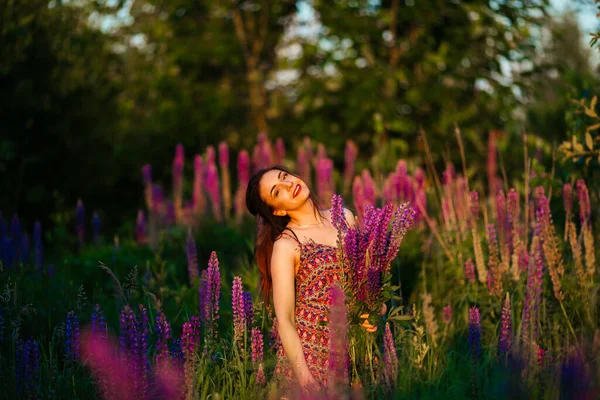 一个美丽的女孩在一个紫色的田野里 手里拿着一束丁香花的女孩 — 图库照片