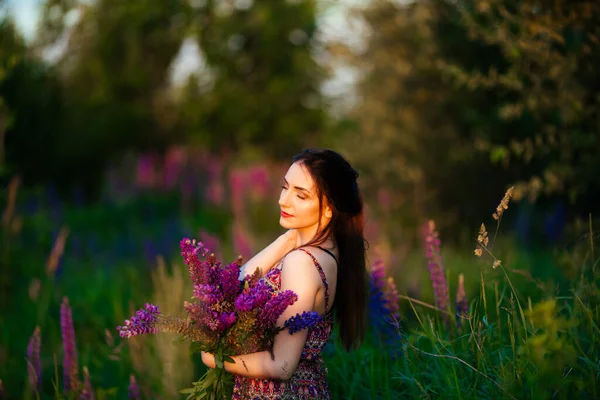 夕暮れ時に畑にいた若い女性 花を持つ — ストック写真