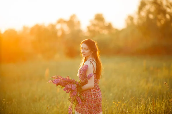 抱着花的女孩 布鲁内特在战场上日落 — 图库照片