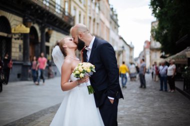 Muhteşem bir düğün çifti, eski şehirde mimari ile güneşli bir günün tadını çıkarıyor..