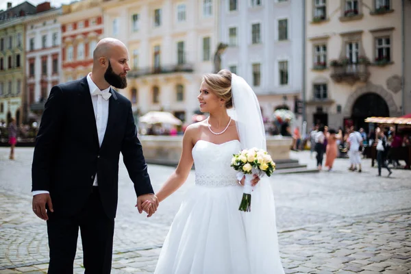 Muhteşem bir düğün çifti, eski şehirde mimari ile güneşli bir günün tadını çıkarıyor..
