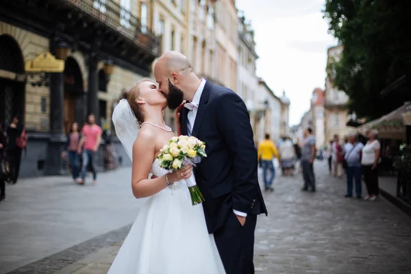 Muhteşem bir düğün çifti, eski şehirde mimari ile güneşli bir günün tadını çıkarıyor..
