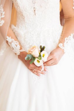 Beyaz elbiseli gelin düğün törenine hazırlanırken poz veriyor..